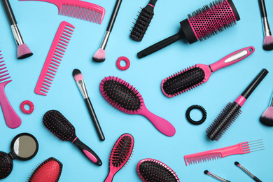 Photo of Flat lay composition with modern hair combs and brushes on light background