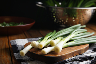 Fresh green spring onions on wooden board