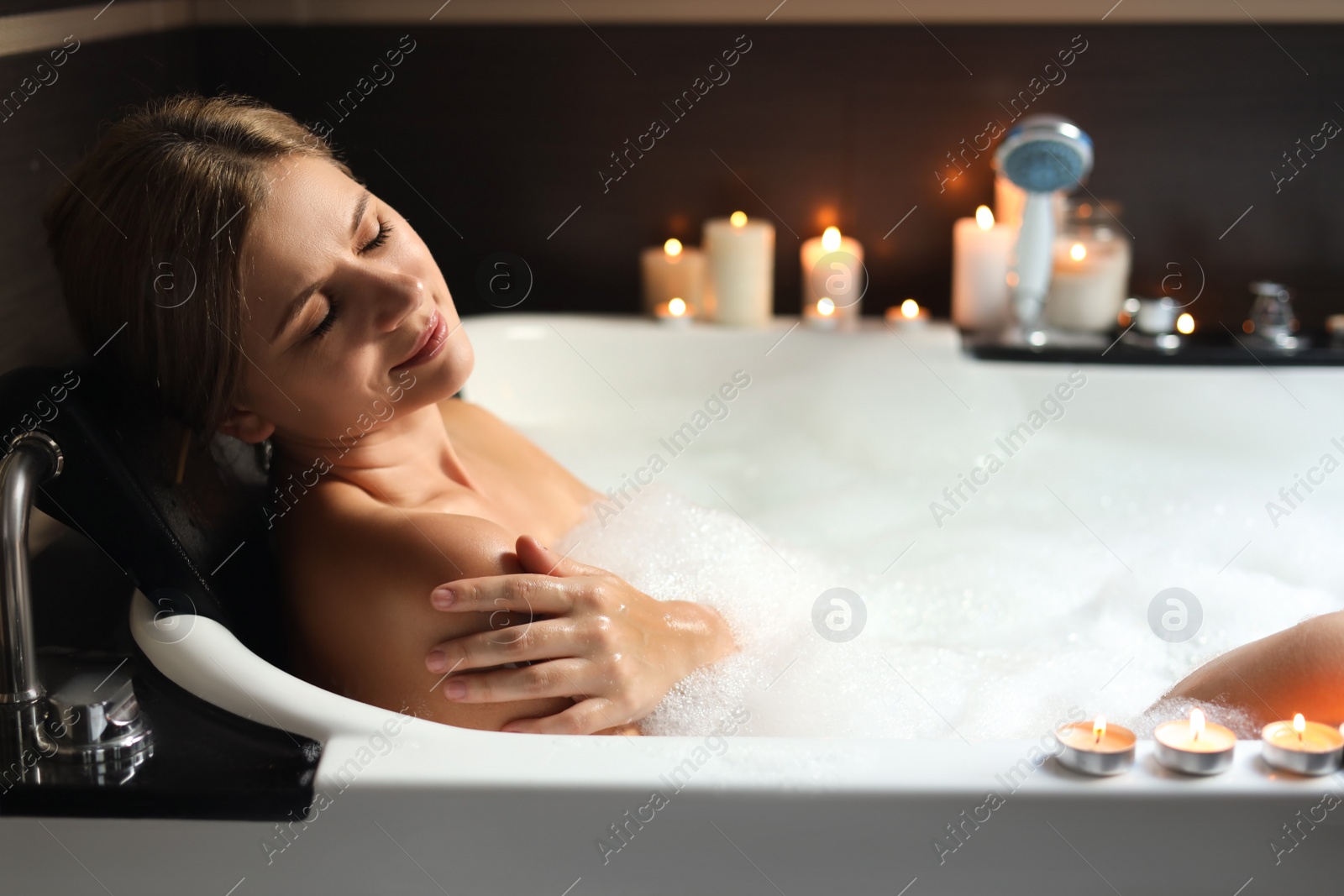 Photo of Beautiful woman taking bubble bath indoors. Romantic atmosphere