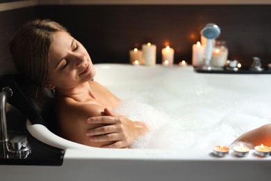 Photo of Beautiful woman taking bubble bath indoors. Romantic atmosphere