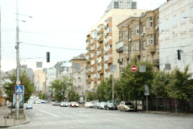 Blurred view of quiet city with buildings and cars on road