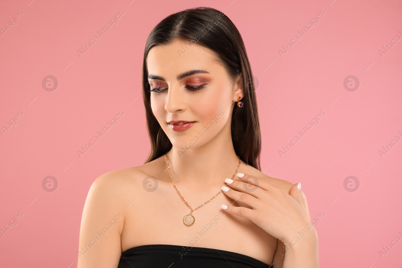 Photo of Beautiful woman with elegant jewelry on pink background