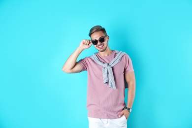 Young man with trendy hairstyle on color background