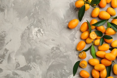 Photo of Fresh ripe kumquats on light grey table, flat lay. Space for text