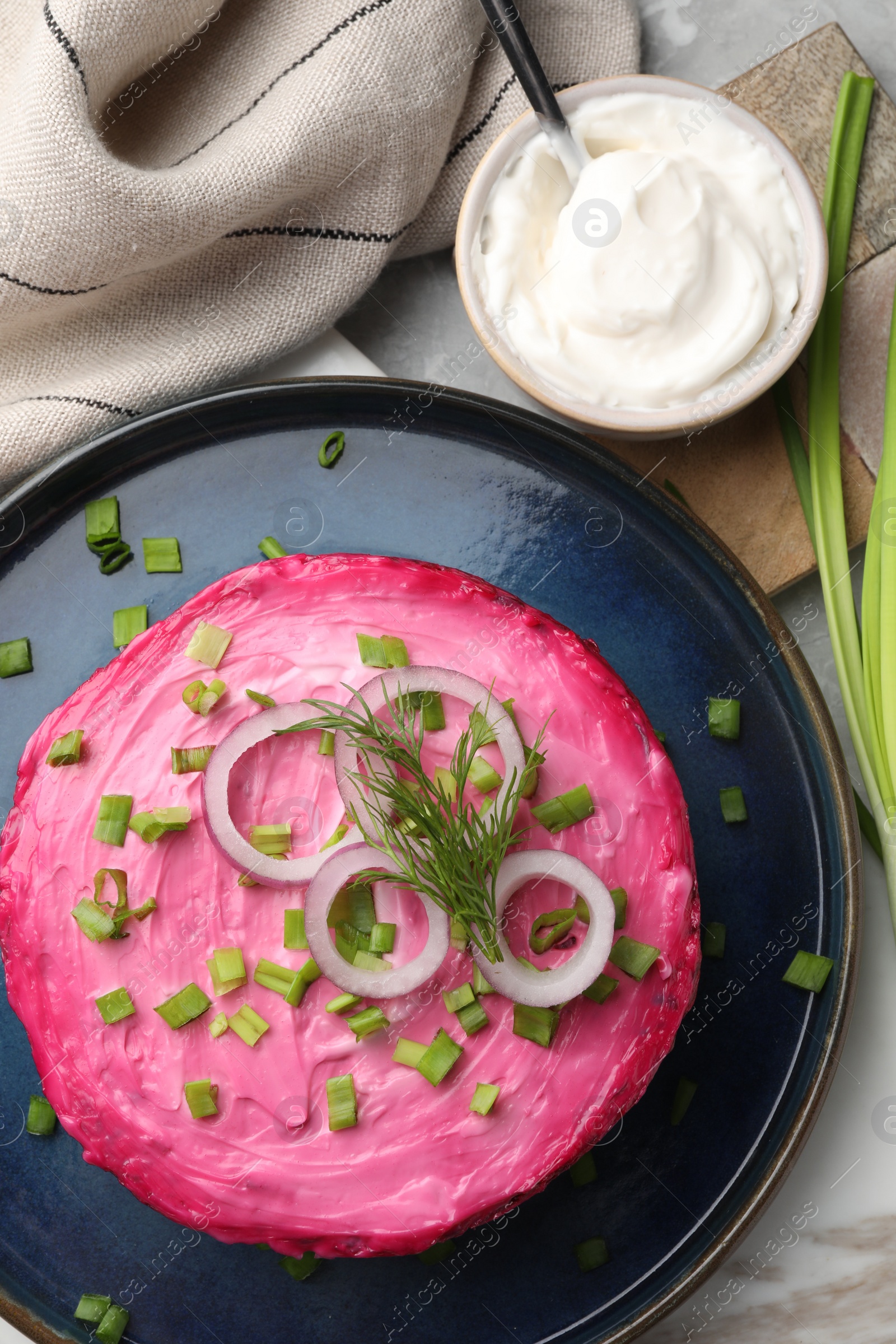 Photo of Herring under fur coat salad on light grey table, flat lay. Traditional Russian dish