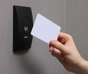 Photo of Woman opening magnetic door lock with key card, closeup. Home security