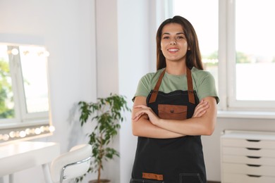 Photo of Portrait of professional hairdresser in beauty salon. Space for text