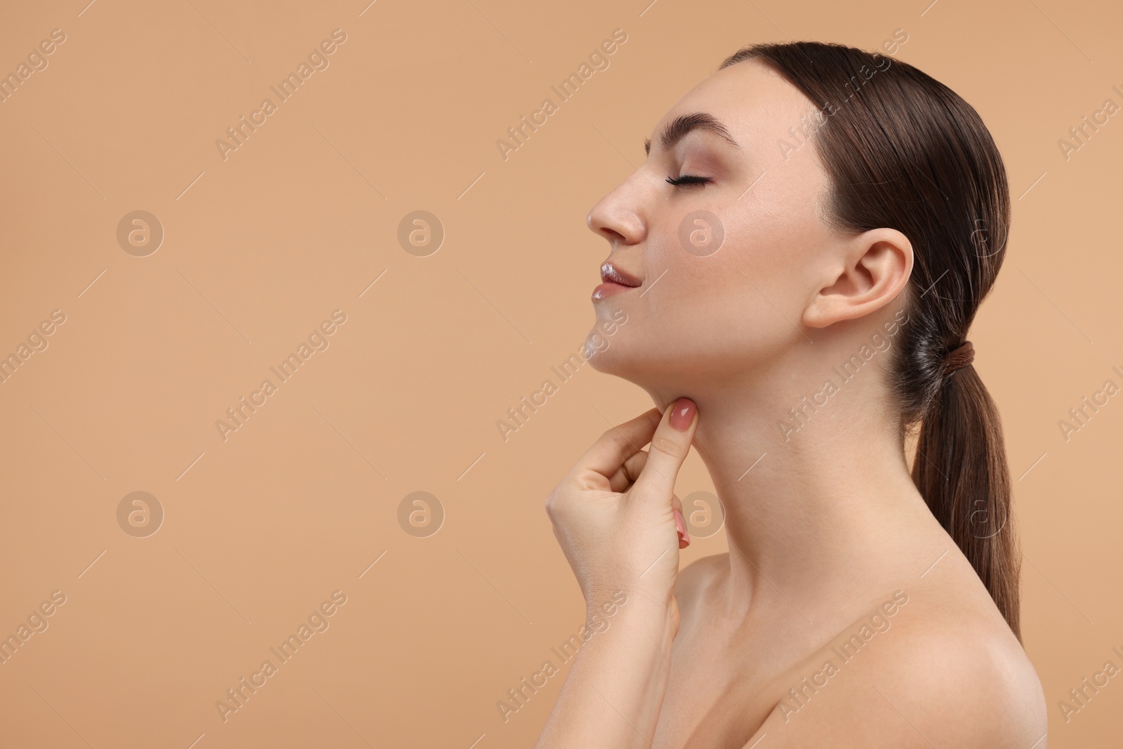 Photo of Beautiful woman touching her chin on beige background. Space for text
