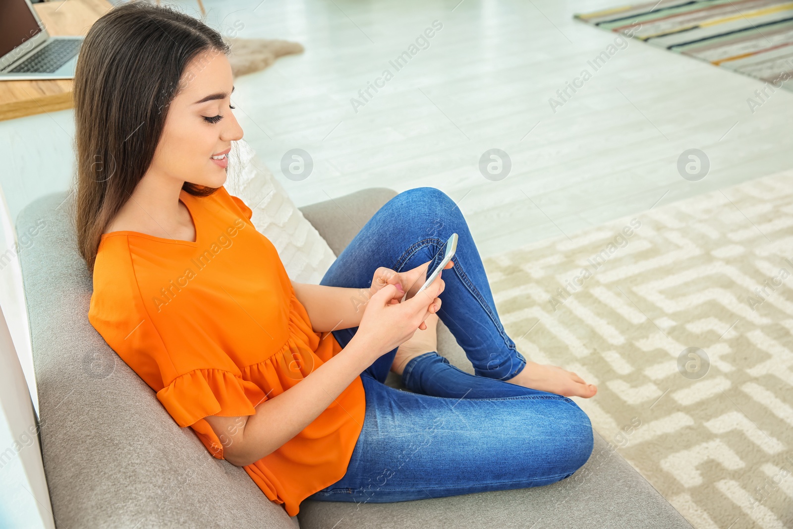 Photo of Attractive young woman using mobile phone at home