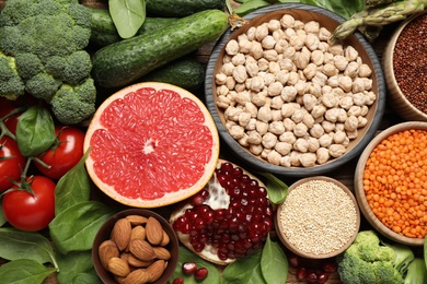 Photo of Fresh vegetables, fruits and seeds on wooden table, flat lay