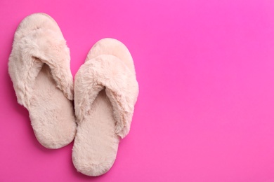 Pair of stylish soft slippers on pink background, flat lay. Space for text