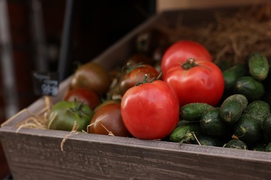 Photo of Fresh ripe vegetables in wooden crate at market, closeup