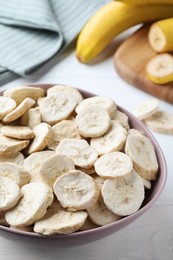Photo of Freeze dried and fresh bananas on white wooden table, closeup