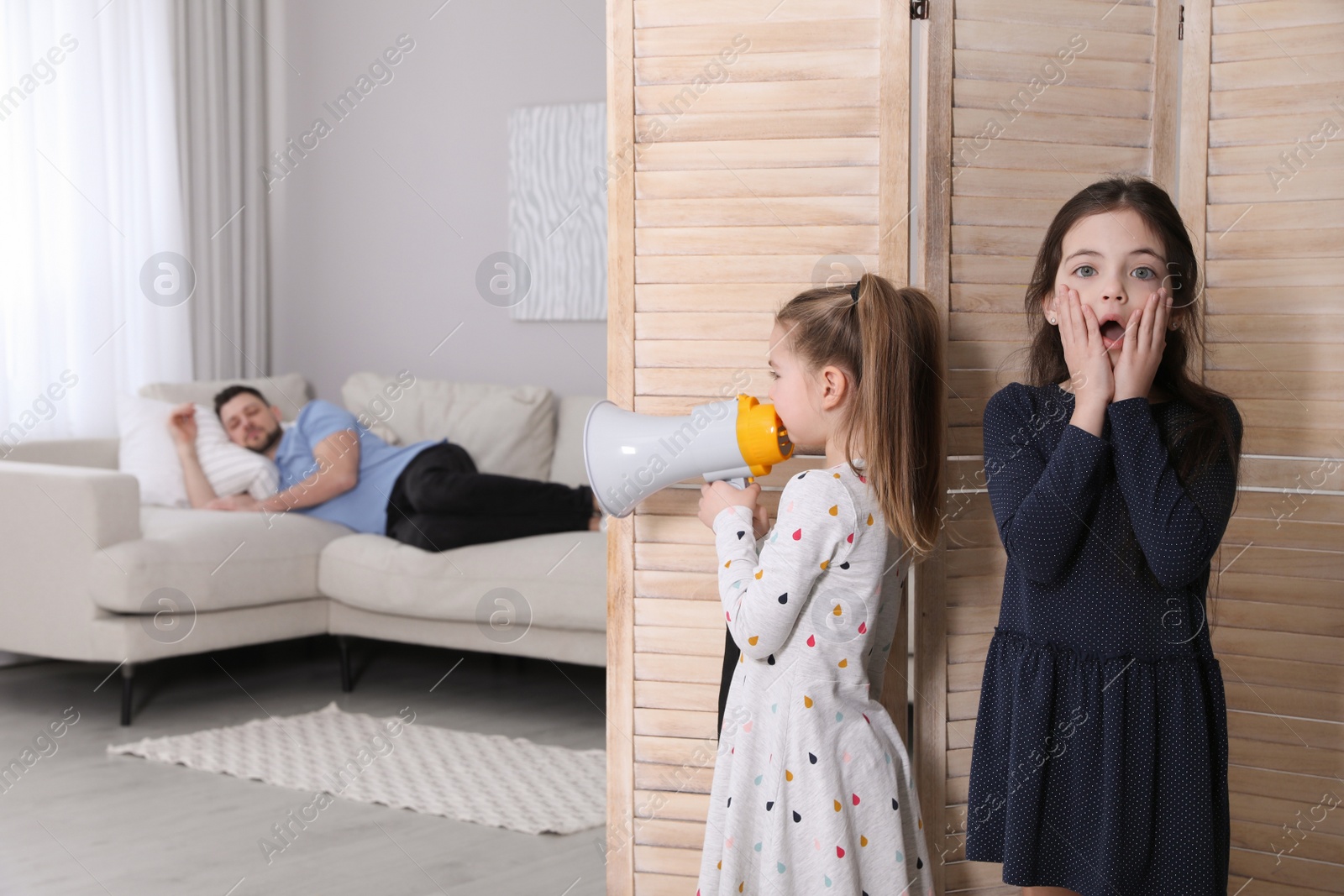 Photo of Cute little children with megaphone waking up their father at home