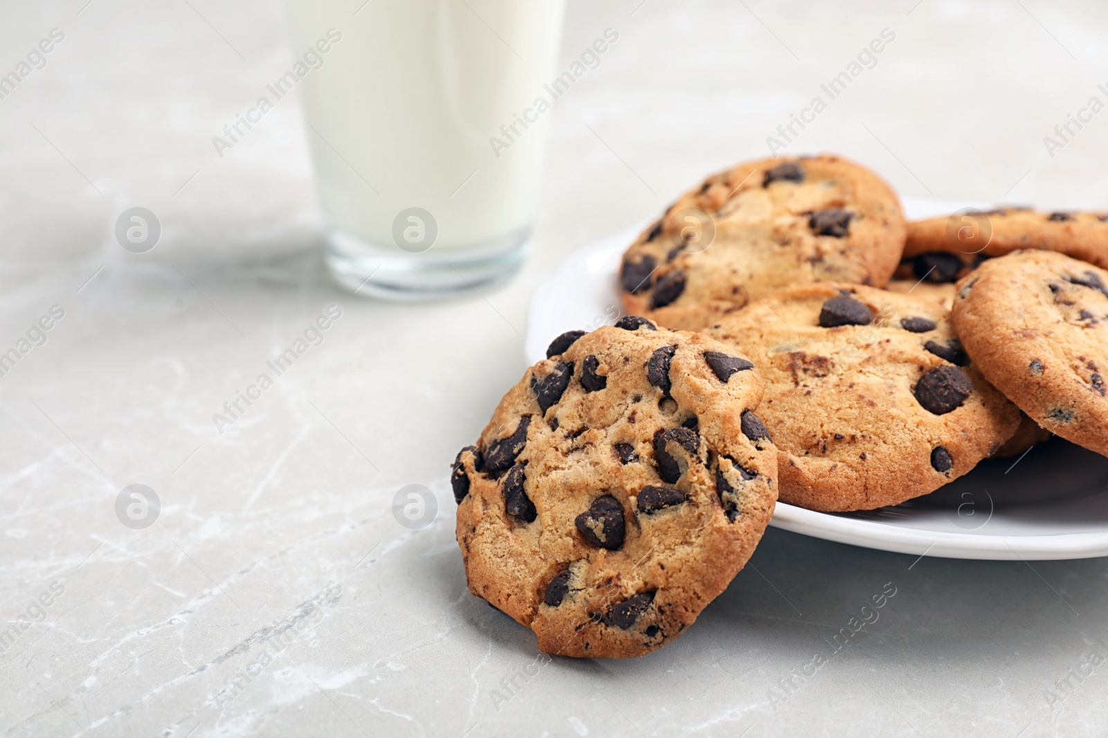 Photo of Plate with tasty chocolate cookies on gray table