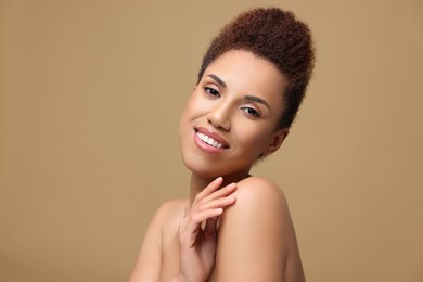 Photo of Portrait of beautiful young woman with glamorous makeup on light brown background