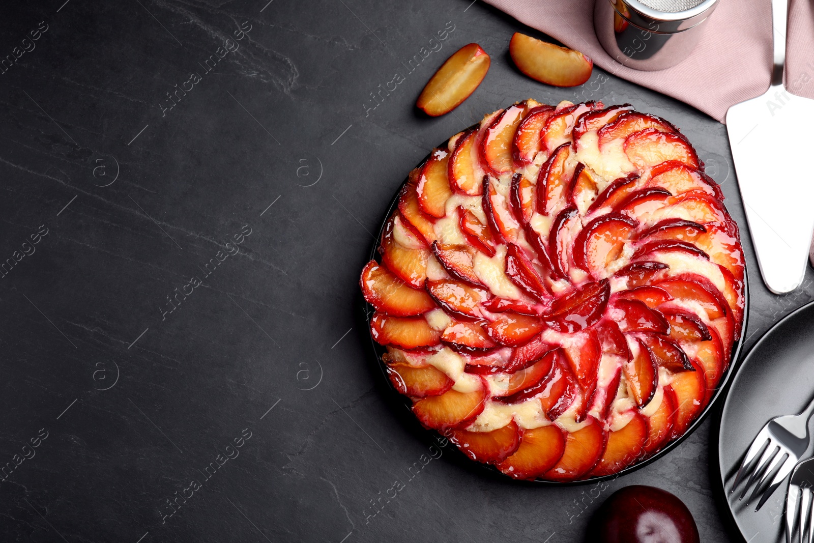 Photo of Delicious cake with plums on grey table, flat lay. Space for text