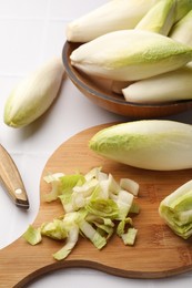 Photo of Fresh raw Belgian endives (chicory) on white tiled table