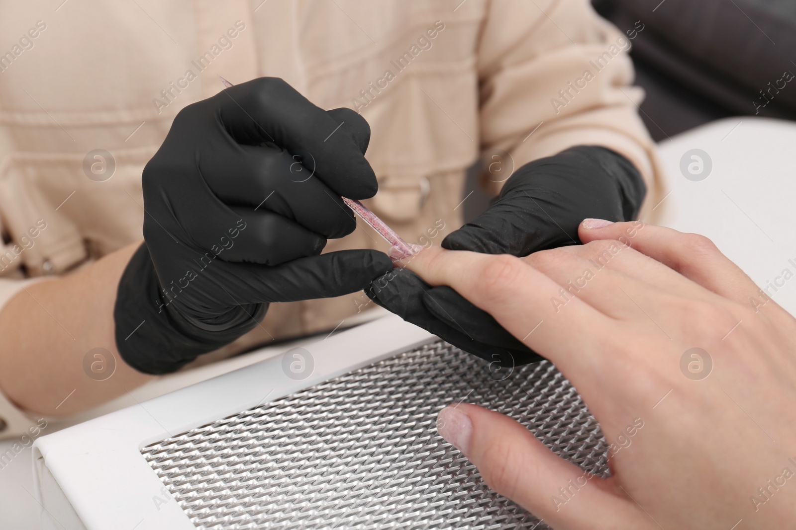 Photo of Professional manicurist working with client, closeup view