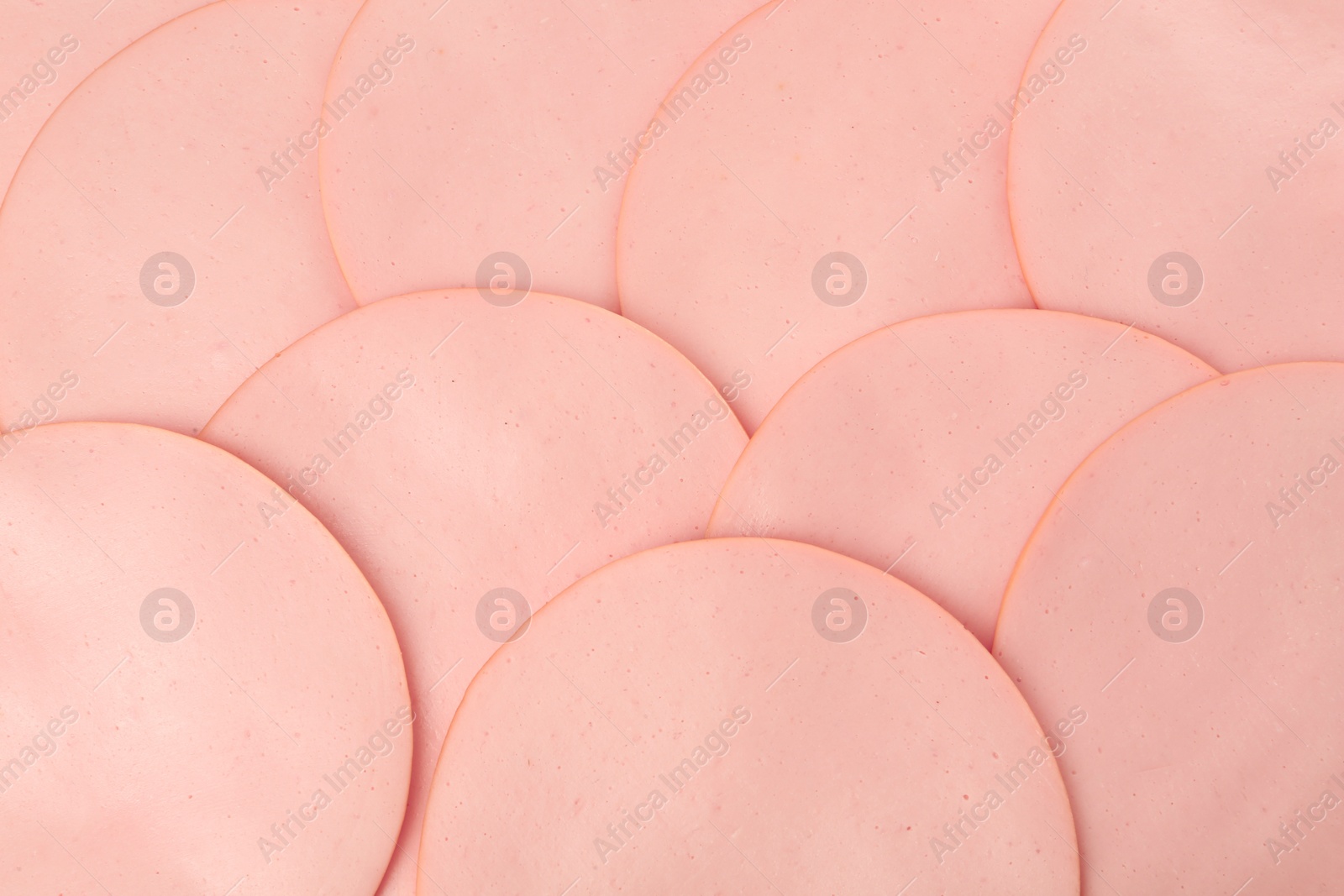 Photo of Slices of delicious boiled sausage as background, top view