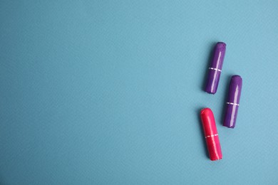 Photo of Colorful tampons on blue background, flat lay. Space for text