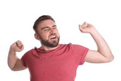 Sleepy young man yawning on white background