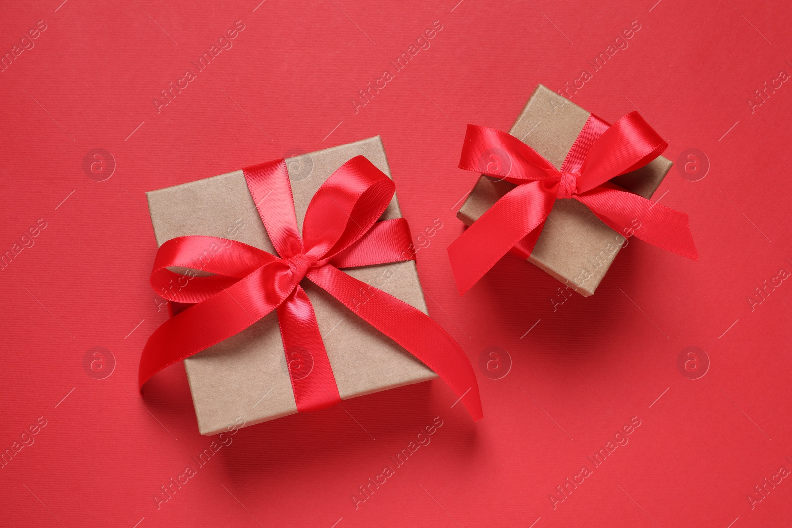 Photo of Beautiful gift boxes on red background, flat lay