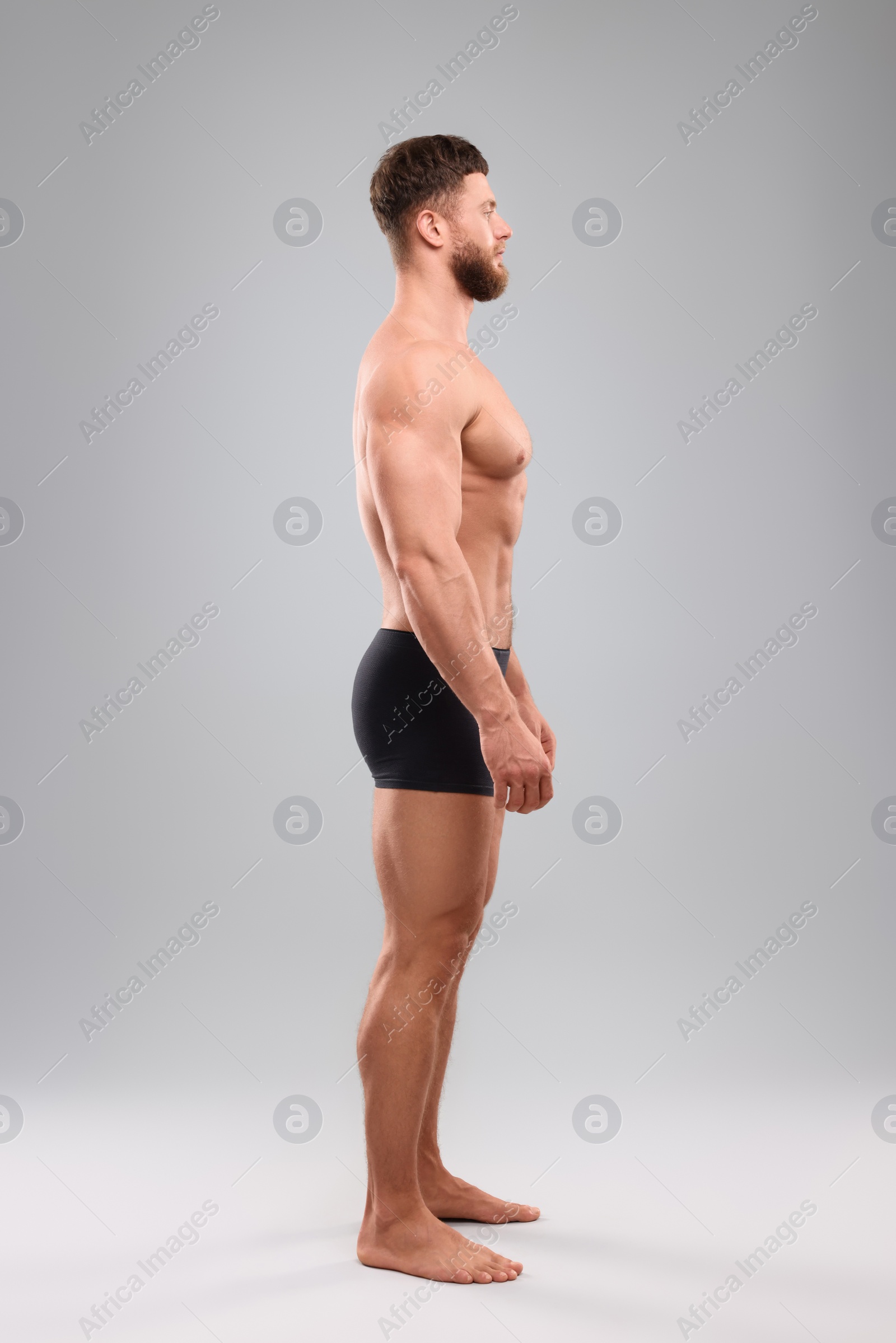 Photo of Handsome muscular man on light grey background. Sexy body