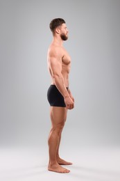 Handsome muscular man on light grey background. Sexy body