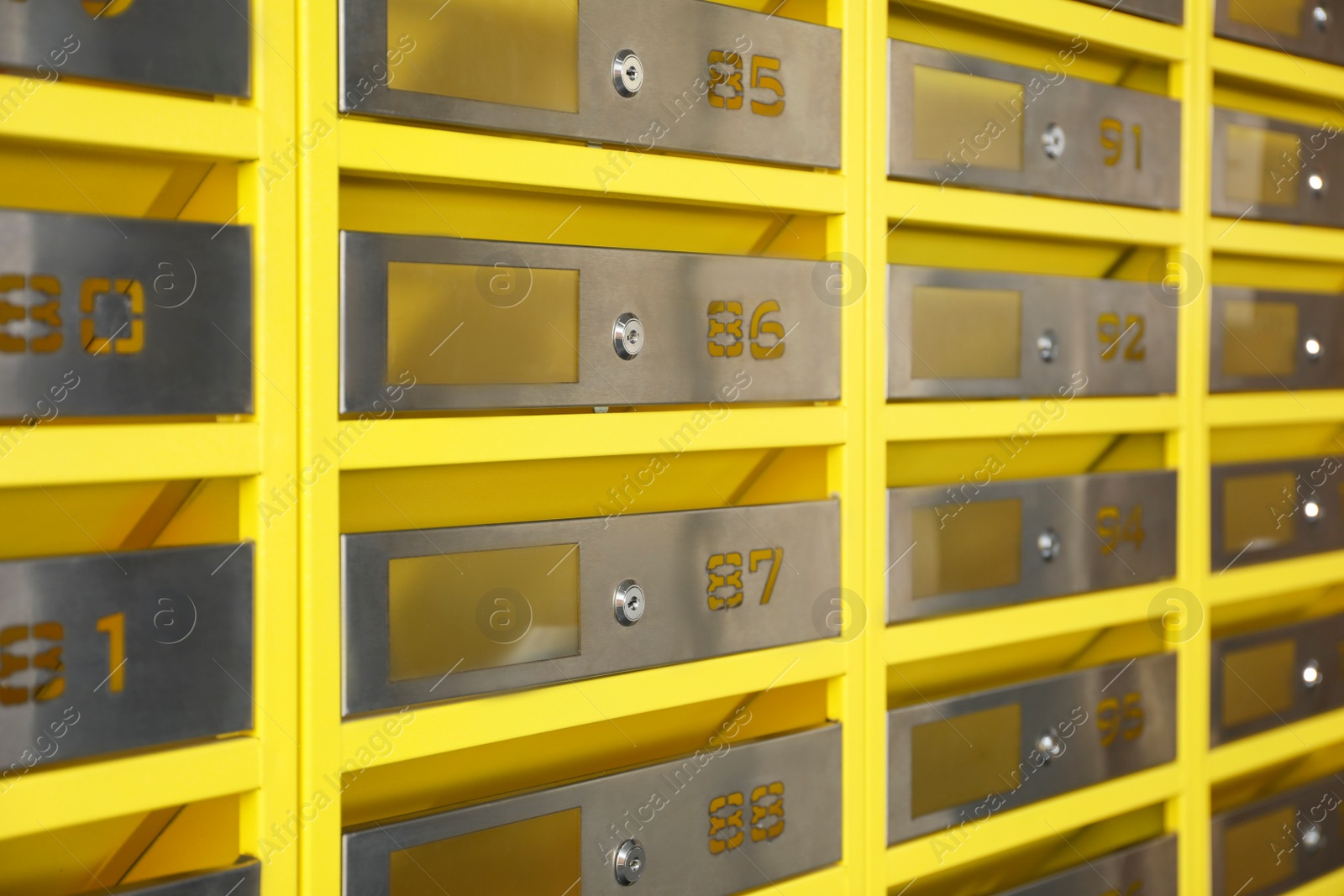 Photo of Many closed metal mailboxes with keyholes and numbers as background, closeup