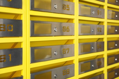 Photo of Many closed metal mailboxes with keyholes and numbers as background, closeup