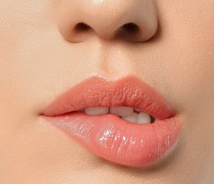 Photo of Beautiful young woman biting lip on grey background, closeup