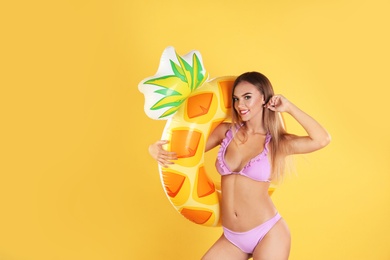 Pretty sexy woman in stylish bikini with inflatable ring on color background