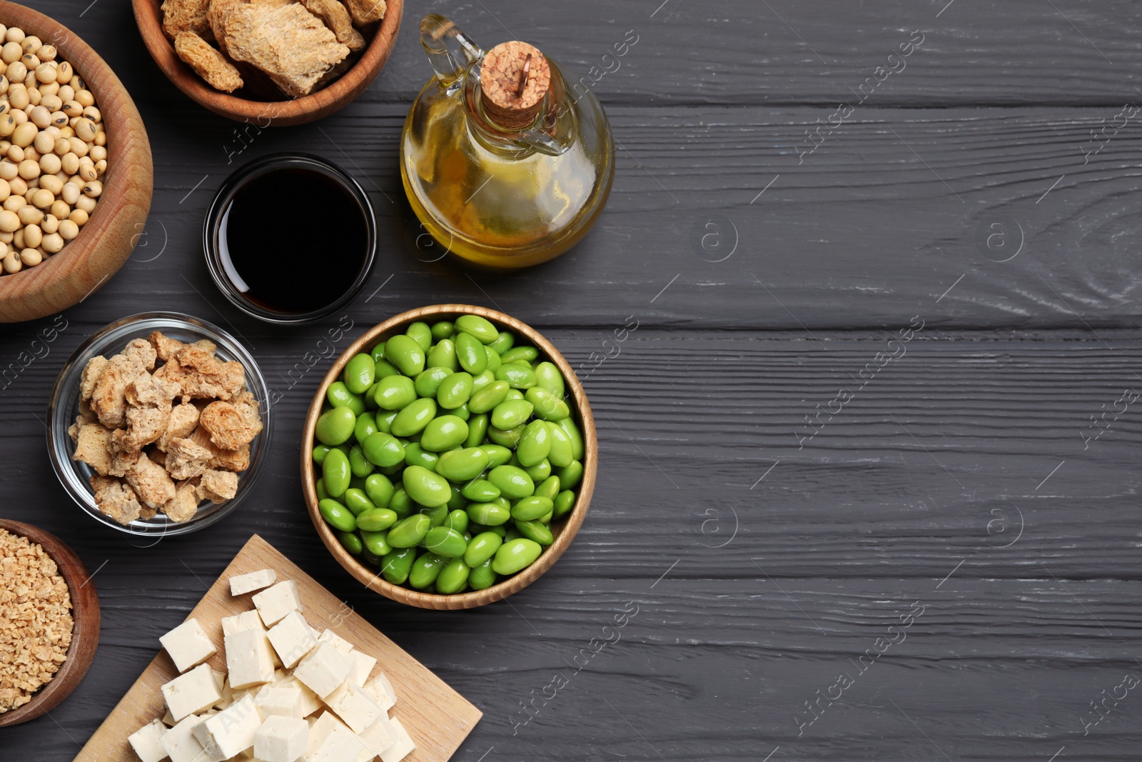 Photo of Different organic soy products on grey wooden table, flat lay. Space for text