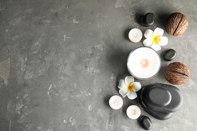 Spa composition with stones and candles on table, flat lay. Space for text