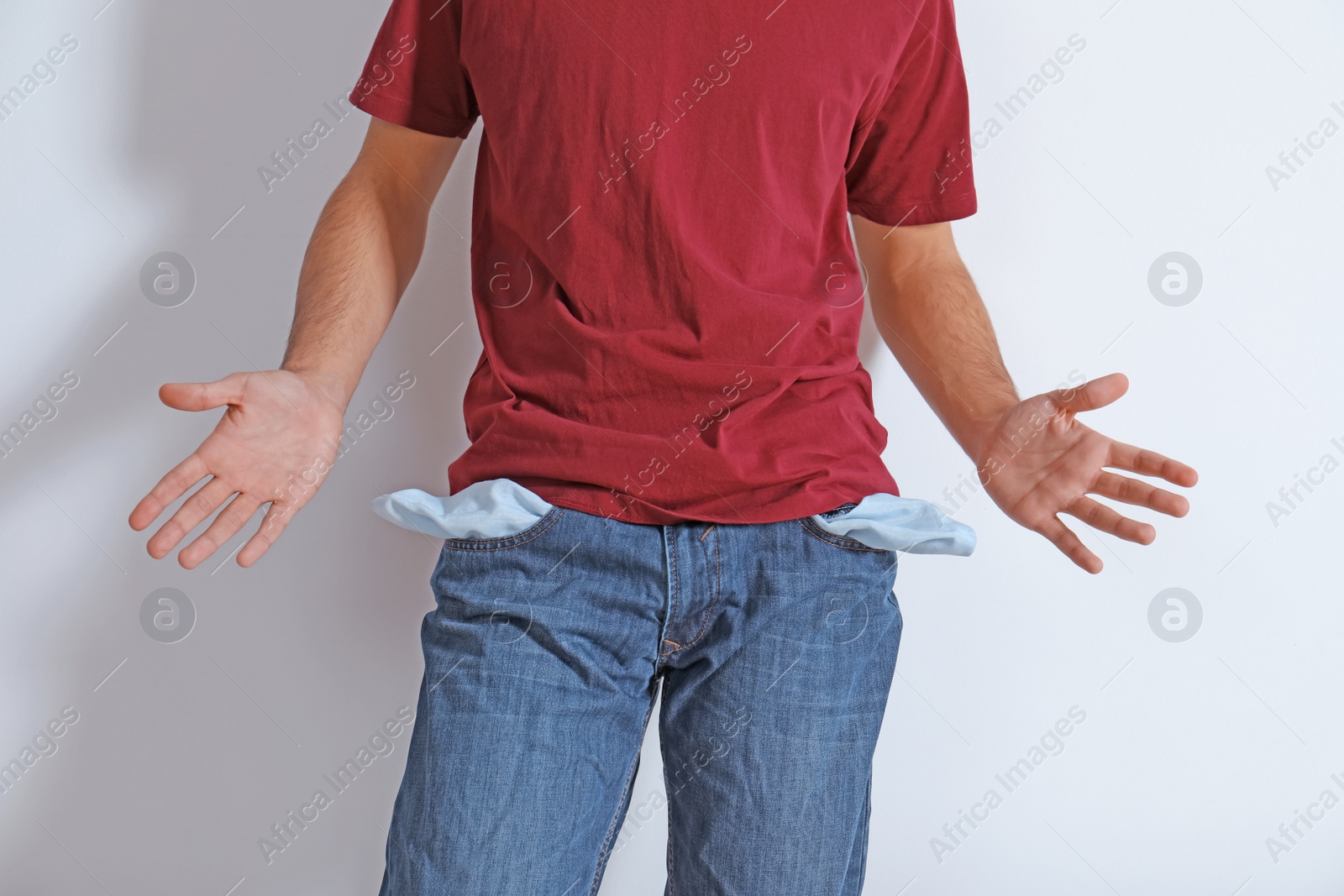 Photo of Man showing empty pockets on light background, closeup
