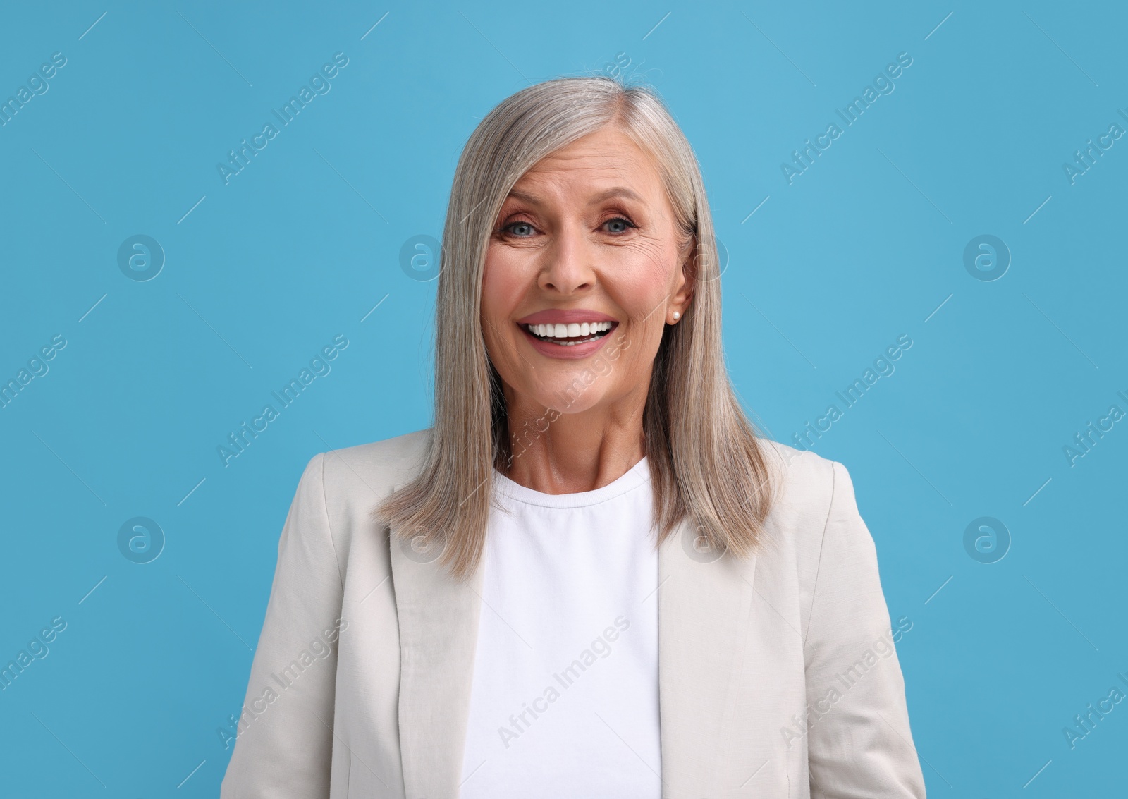 Photo of Portrait of beautiful middle aged woman on light blue background