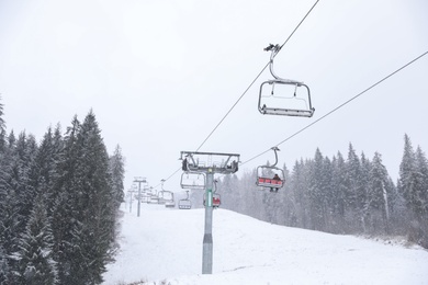 Photo of Ski lift at snowy mountain resort. Winter vacation