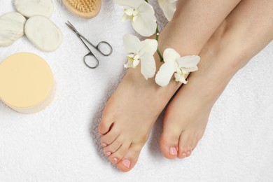 Photo of Woman with neat toenails after pedicure procedure on white terry towel, closeup