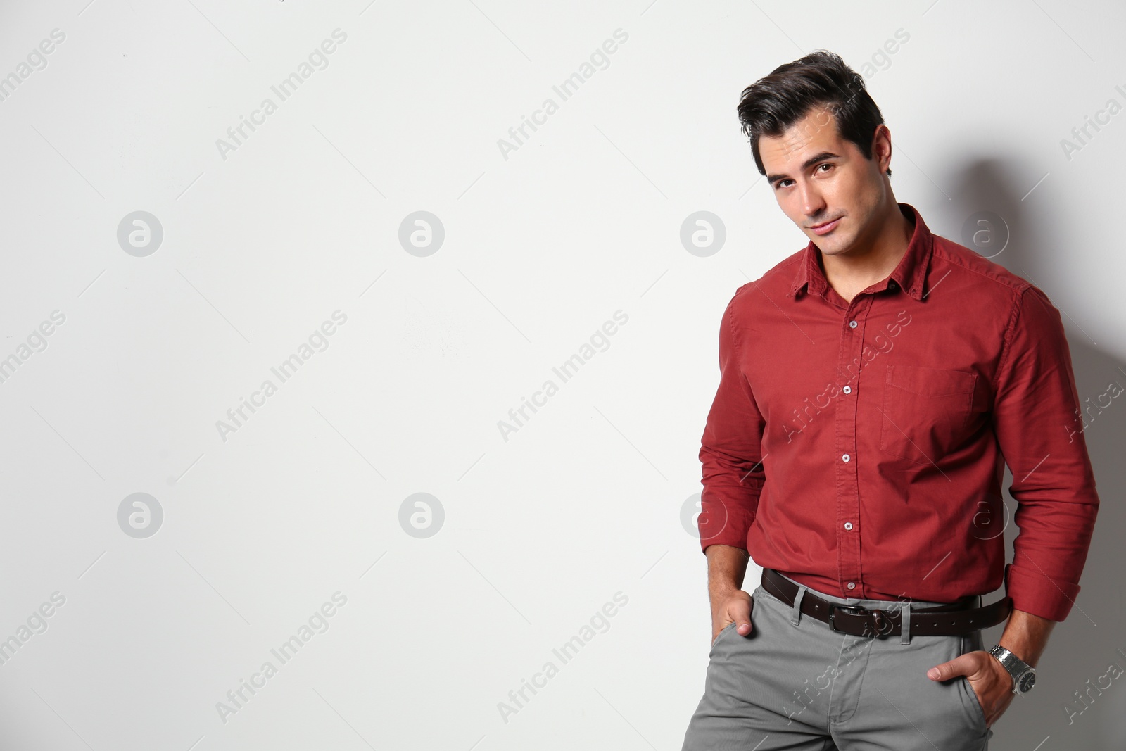 Photo of Handsome young man in stylish clothes on light beige background. Space for text