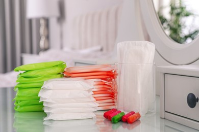 Photo of Different feminine hygiene products on dressing table in bedroom