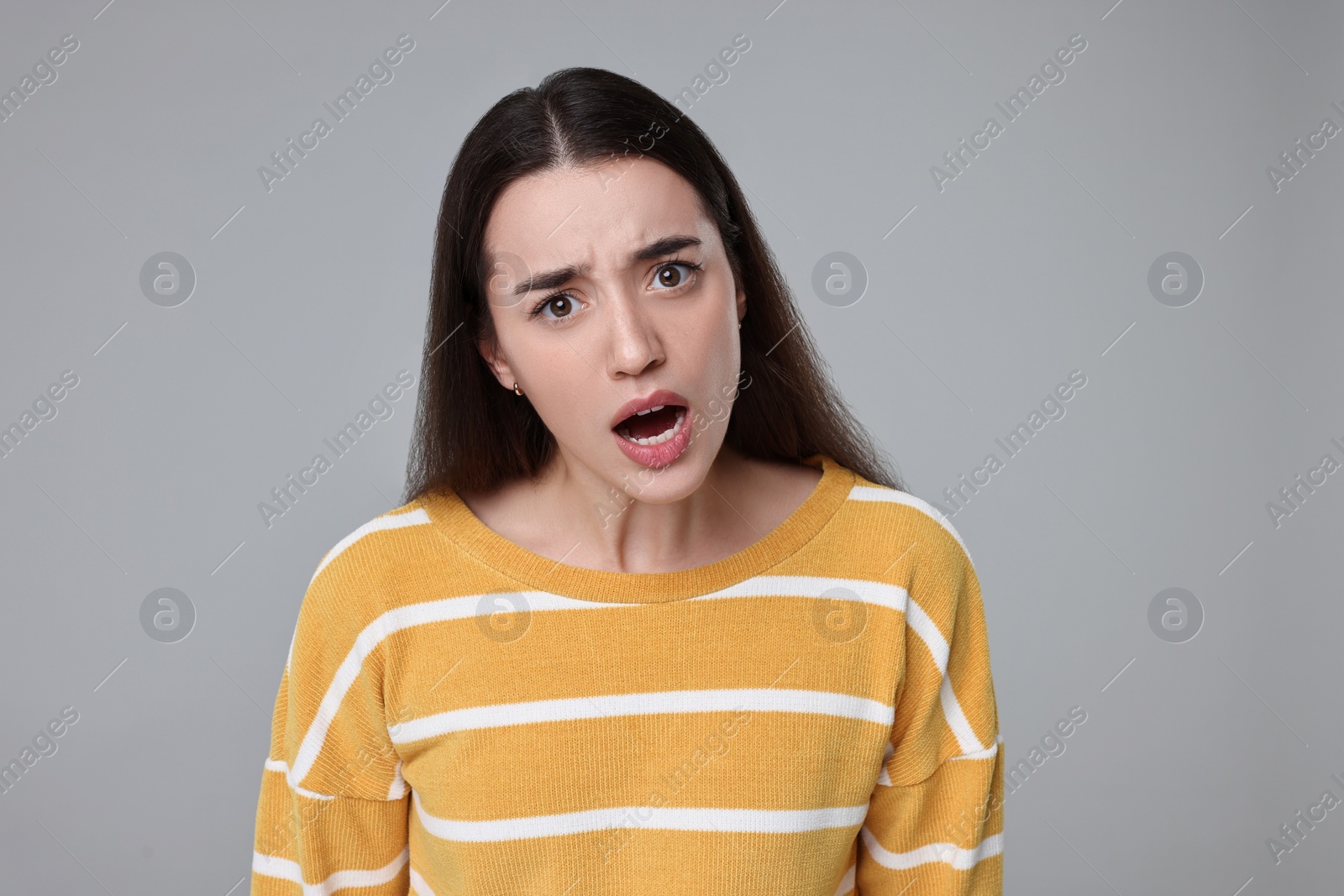 Photo of Portrait of surprised woman on grey background