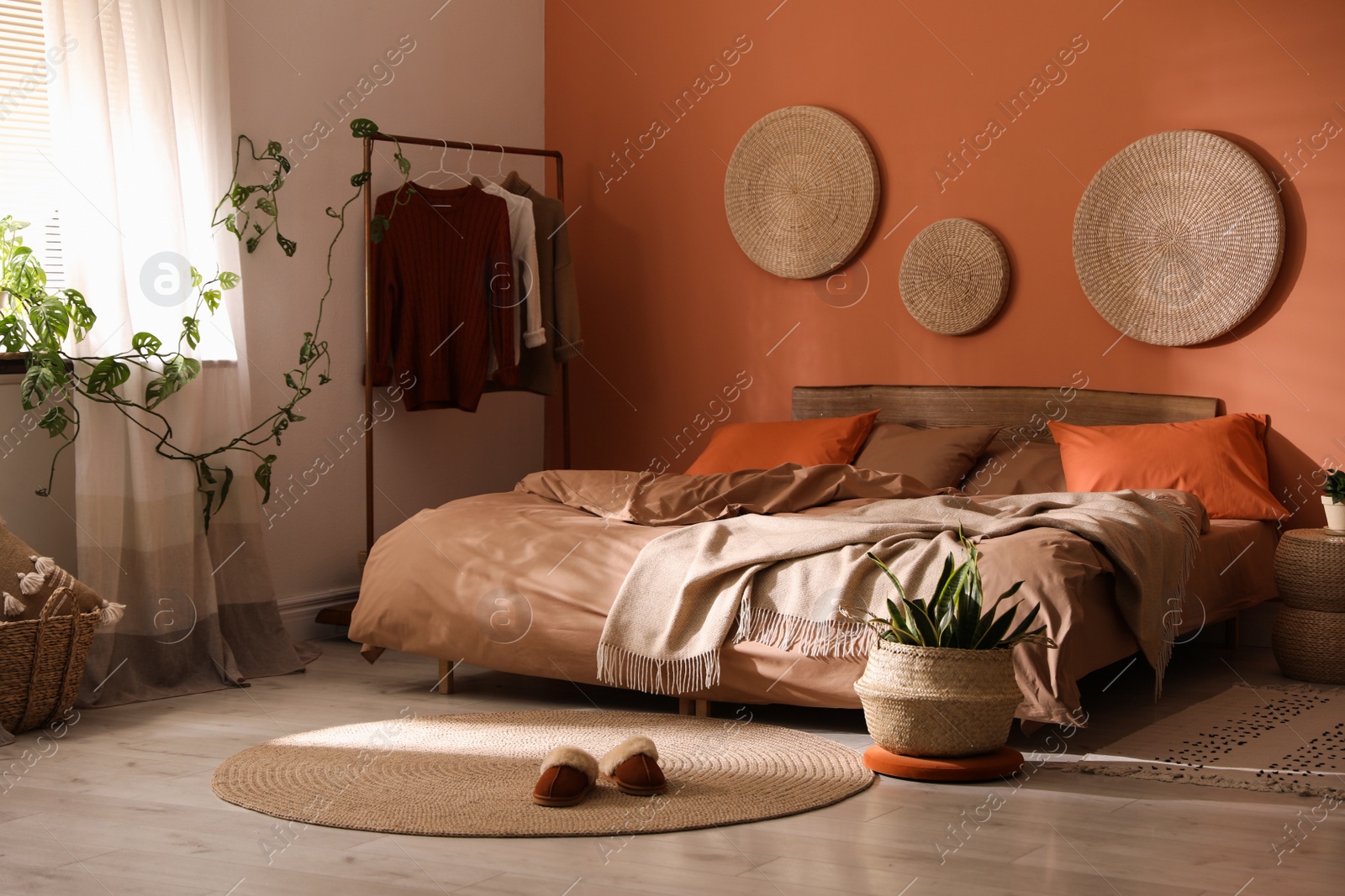Photo of Bed with orange and brown linens in stylish room interior