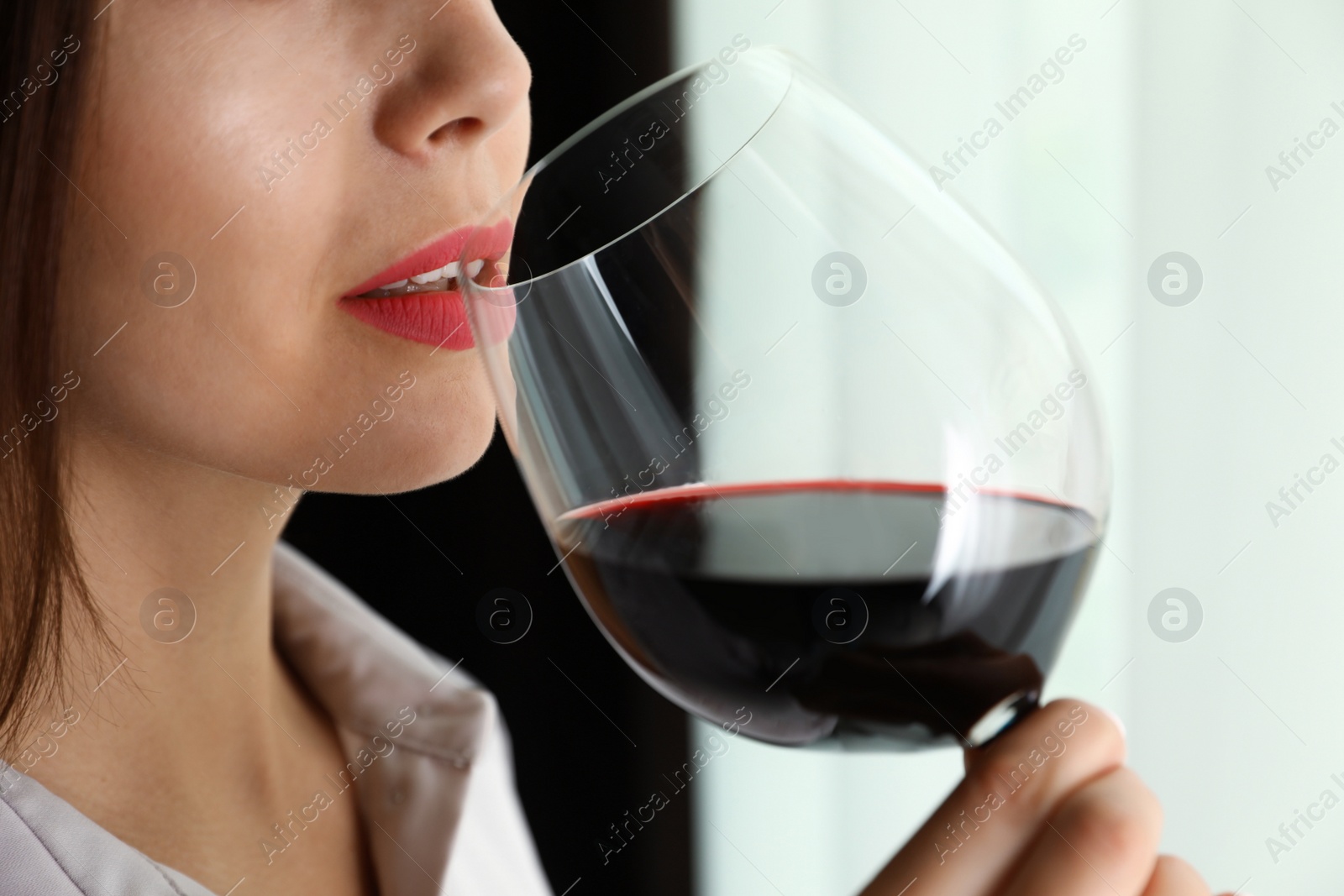 Photo of Young woman with glass of luxury red wine indoors, closeup view