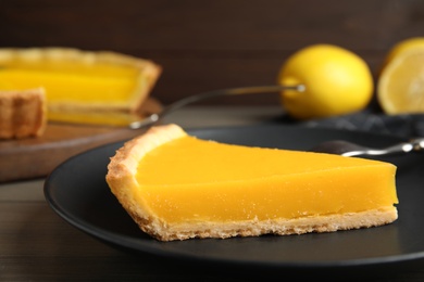 Photo of Delicious homemade lemon pie on wooden table, closeup