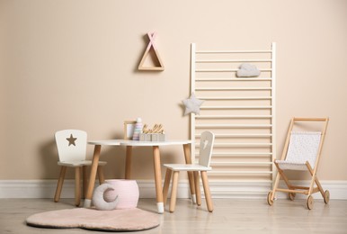 Baby room interior with stylish table, chairs and toys