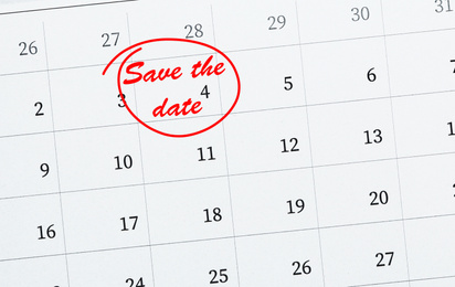 Paper calendar with phrase SAVE THE DATE, closeup