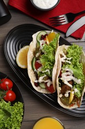 Delicious fresh vegan tacos served on wooden table, flat lay