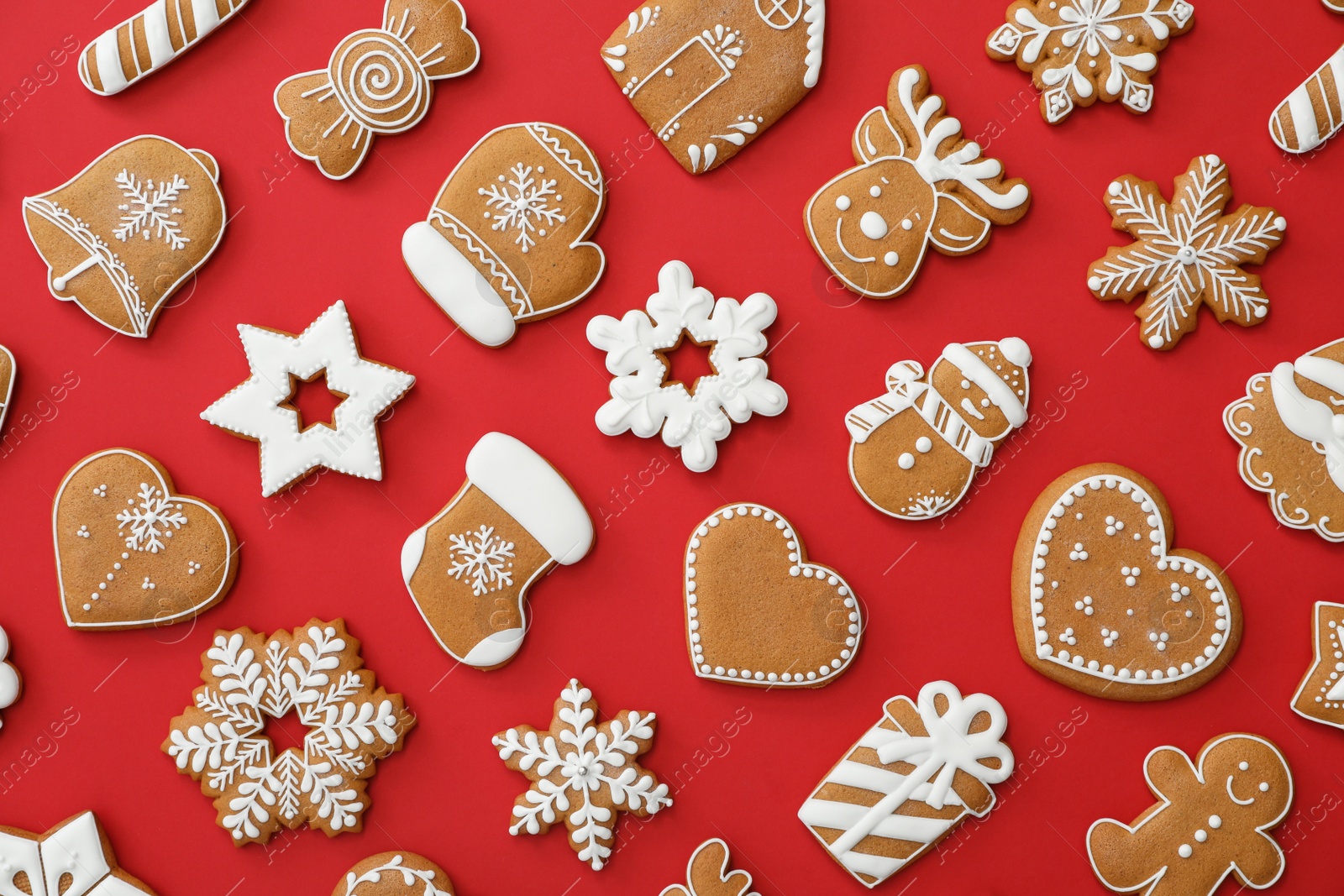 Photo of Different Christmas gingerbread cookies on red background, flat lay