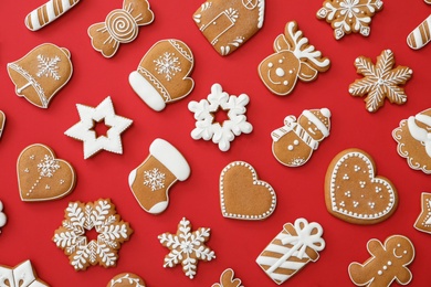 Different Christmas gingerbread cookies on red background, flat lay